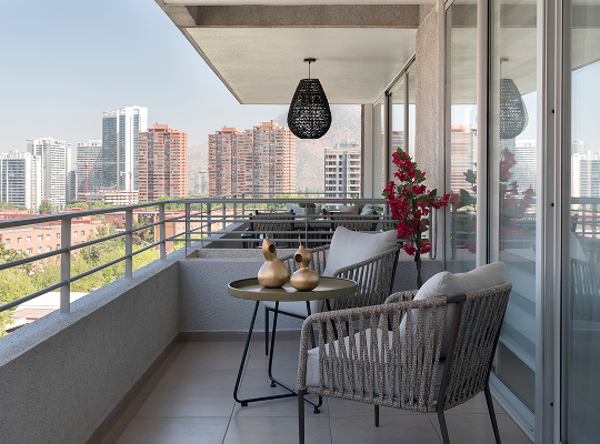 Sala moderna con sofá en L beige, sillones curvos y pared decorativa con papel tapiz geométrico en tonos grises